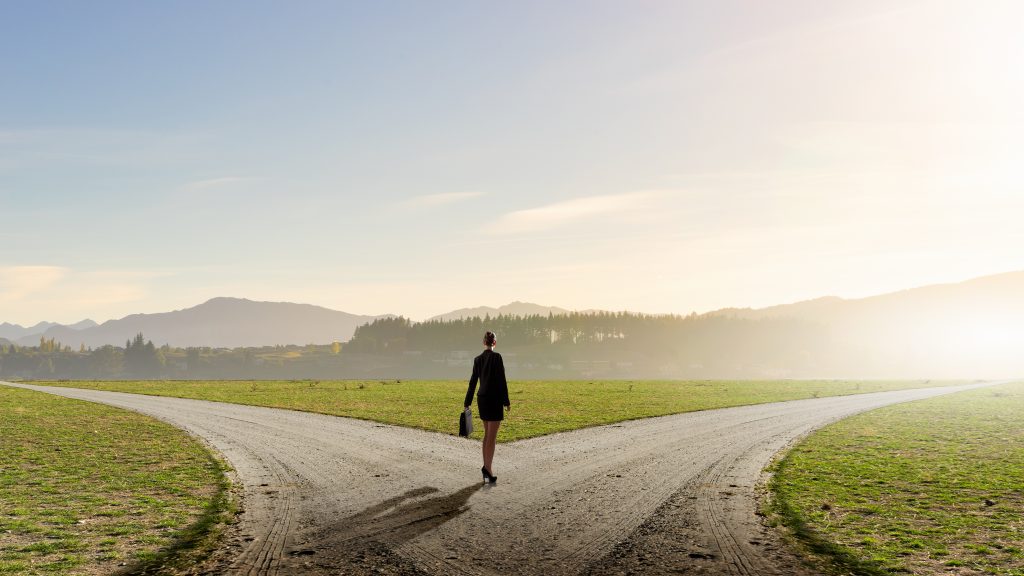 Back view of businesswoman standing on crossroads and making choice